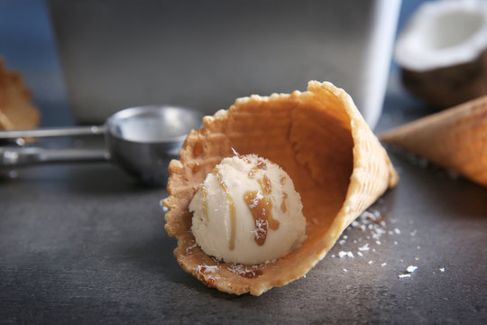 Fresh coconut ice cream in wafer cone on table