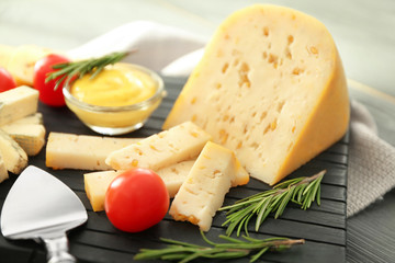 Composition of assorted cheese on black wooden board