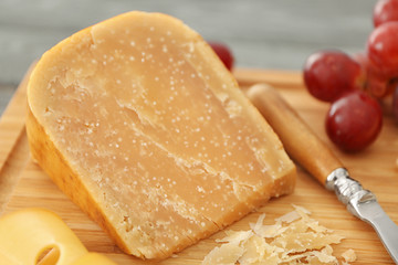 Delicious cheese with grape on wooden board