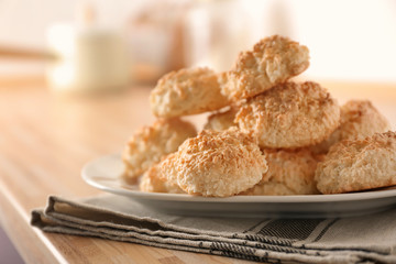 Plate with delicious coconut macaroons on table