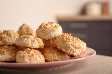Plate with delicious coconut macaroons on table