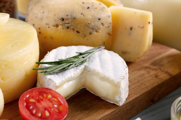 Composition with variety of cheese on wooden board