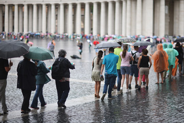 People with umbrellas in the rain in St. Peter's Square in the Vatican. Rome, Italy