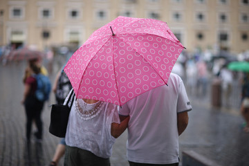 People with umbrellas in the rain in St. Peter's Square in the Vatican. Rome, Italy
