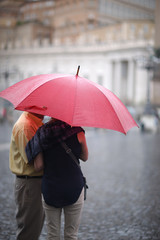 A man and a woman with an umbrella in the rain in St. Peter's Square in the Vatican. Rome, Italy