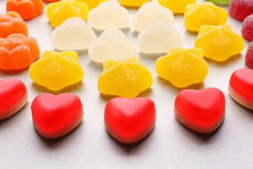 Composition of tasty jelly candies on light background, closeup