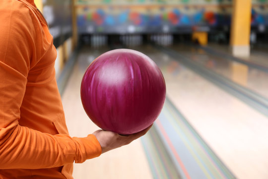 Young man with ball in bowling club, closeup