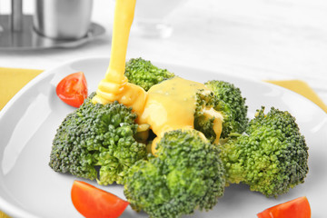Plate with broccoli and cheese sauce, closeup