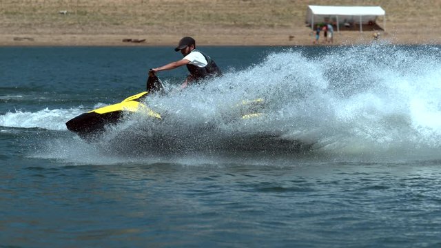 Man riding personal water craft on lake