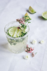 summer homemade juice with lime and blossom on stone table background