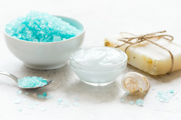 Obraz na płótnie Canvas blue sea salt, soap and body cream on stone desk background