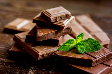 chocolate pieces with mint on wooden table background