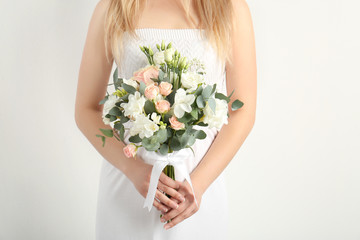 Beautiful bride holding bouquet with  freesia flowers on white background