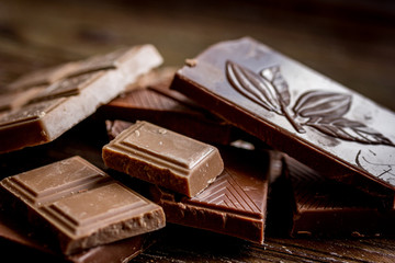 black and milk chocolate bars dark wooden table background