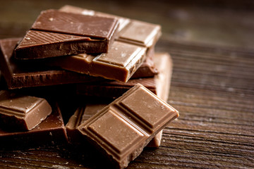 black and milk chocolate bars dark wooden table background