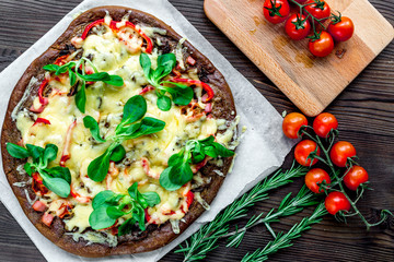 cooking pizza with vegetables and cheese on wooden desk background top view