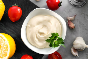 Delicious mayonnaise in bowl on kitchen table
