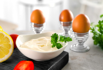 Delicious mayonnaise in bowl on kitchen table