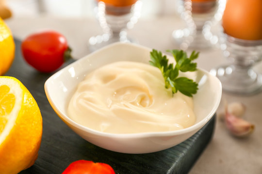 Delicious mayonnaise in bowl on kitchen table, closeup