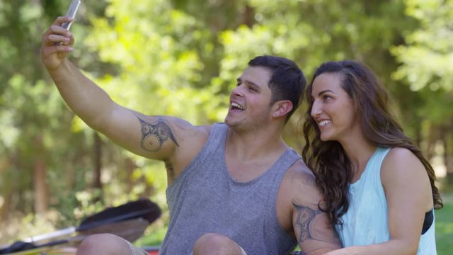 Couple outdoors taking cell phone selfies