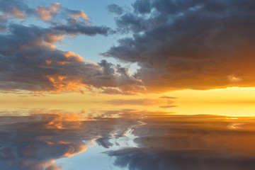 Cumulus sunset clouds with sun setting down