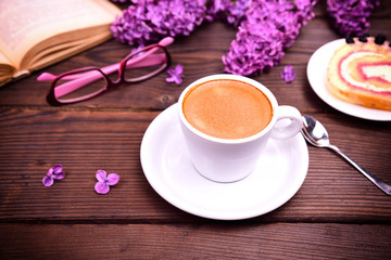 Espresso in a white cup with a saucer on a brown table