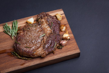 Grilled ribeye steak of marble beef with spices on wooden Board. With copy space