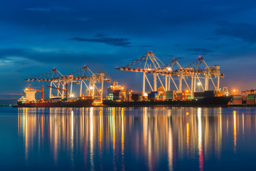 Fototapeta na wymiar Industrial port with containers cargo ship in the trade port, shipping, transportation, logistic import export at sunset, twilight time.