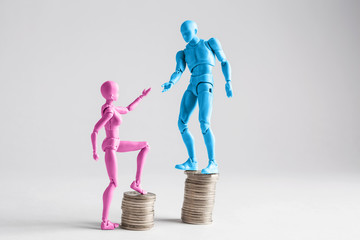 Income inequality concept shown with realistic male and female figurines and piles of coins