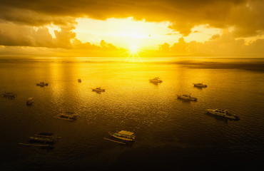 Aerial view of boats on sunrise in bali beach Indonesia.