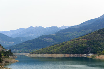Mountains covered by pine forests descending to lake