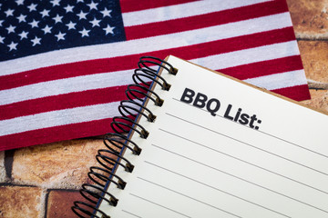 BBQ List concept on notebook with American flag for a patriotic theme