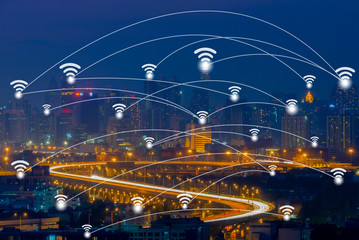 Wifi network connection concept on aerial view of cityscape business district at twilight background.