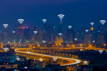 Wifi network connection concept on aerial view of cityscape business district at twilight background.