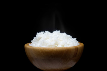 Wooden bowl full of jasmine rice on black