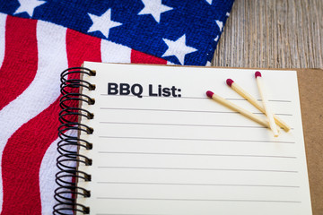 BBQ patriotic theme concept on notebook and wooden board with USA flag and matches