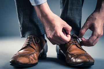 革靴の紐を結ぶ男性
