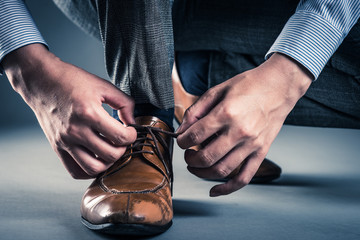 革靴の紐を結ぶ男性