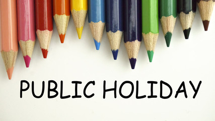 Colored pencils on white paper with word PUBLIC HOLIDAY. back to school concept