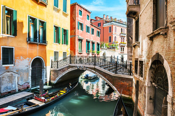 Fototapeta na wymiar Scenic canal with bridge and colorful buildings in Venice, Italy