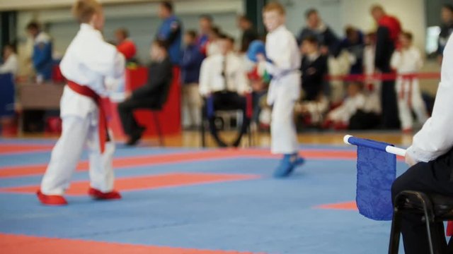 Female karatekas fight on karate competitions, blurred sport background
