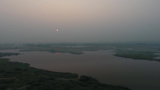 Aerial View. Panoramic summer morning landscape. The picturesque landscape with river, trees and field with Incredible sun. Morning Fog.