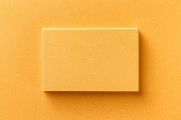 Mockup of horizontal business card stack at golden foil paper background.