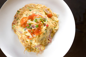 Omelet on rice on white dish