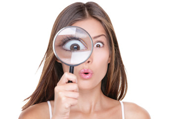 Funny expression. Shocked woman looking through a magnifying glass. Surprised Asian girl looking...