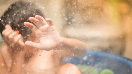 Fototapeta na wymiar Little boy playing water splash