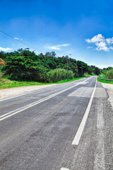 Asphalt road . Clouds on blue sky in summer day