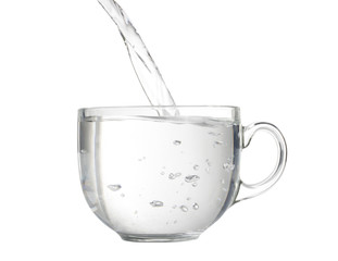 Pouring water into a big glass cup.