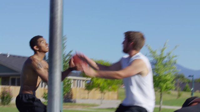 Friends playing basketball at park, slow motion slam dunk