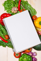 Notebook for culinary recipes with fresh organic vegetables